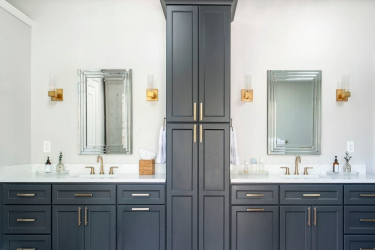  Navy blue bathroom vanity with white countertop and floor-to-ceiling cabinets to the right
