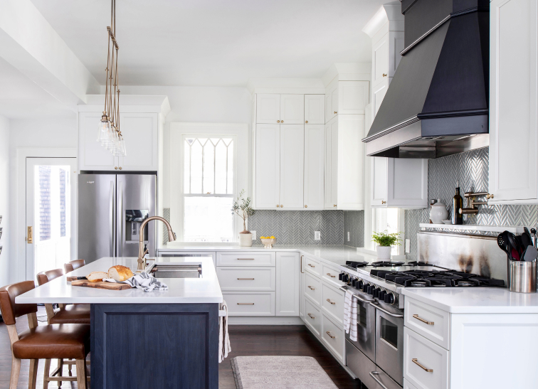 Bright remodeled kitchen with white cabinetry, dark custom range hood and dark blue island