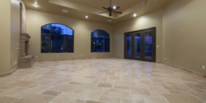 Luxury light tile flooring in a large open space with arched windows on the far wall, and glass patio doors.