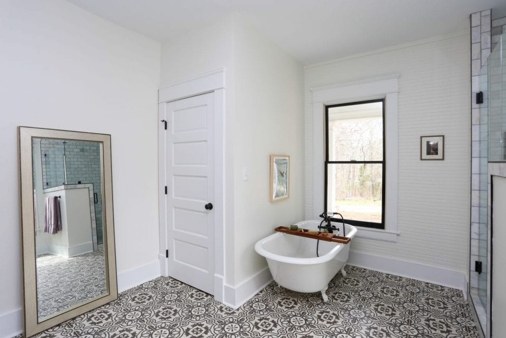 Bathroom with bold tile, white walls and clawfoot bath tub. 
