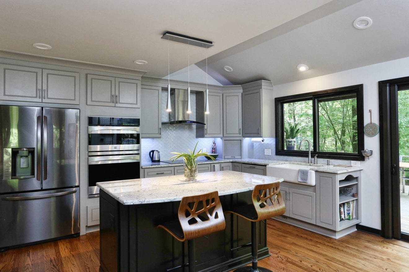  Open concept kitchen with large island and white granite countertops. 