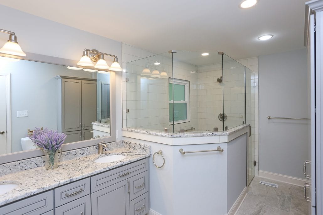 large bathroom with walk in shower and granite sink